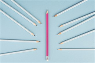 Blue pencils point to the pink one, standing out from the crowd concept, be different, leadership,