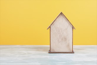 Wooden house, yellow background, buying or renting a house, real estate concept, booking home for