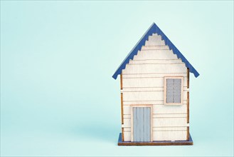 Wooden house, blue background, buying or renting a house, real estate concept, booking home for