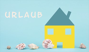 Colorful house on a blue colored background with sea shells, booking an appartment, hotel or lounge