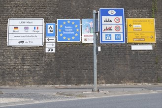 Border crossing to Germany, many road signs inform about speed limits and toll fees on german