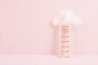 Ladder with a cloud on top, pink rose colored background, copy space, dreaming of success, creative