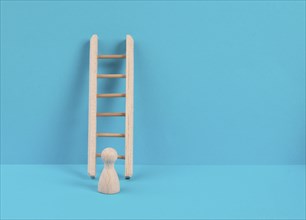 Man is standing next to a ladder, climbing up in career, having a goal, brainstorming for ideas,