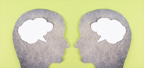 Silhouette of two faces, speech bubble in white color, copy space for text, communication, having