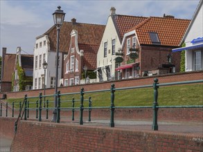 Picturesque gabled houses with red tiled roofs on a sunny day in an old town, greetsiel, east