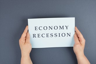 The words economy recession are standing on a paper, inflation and financially crash due to