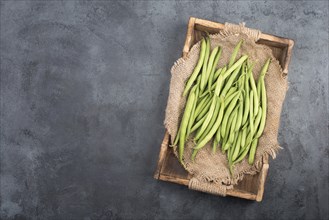 Green string beans on a textured background, empty space for text, vegetables