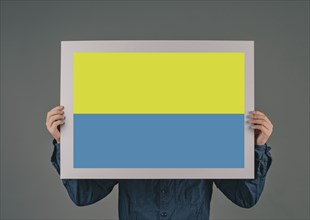 Young man holds a sign with the ukrainain flag, national idendity, war crisis between Ukraine and