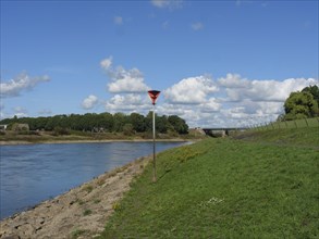 Riverbank with posts under blue sky, Doesburg, Gelderland, Netherlands