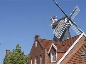 Brick house next to a large mill under a clear sky, Ditzum, rheiderland, Lower Saxony, Germany,