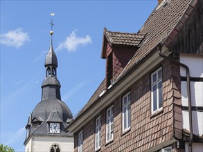 Church tower and half-timbered houses on a sunny day with blue sky, detmold, North