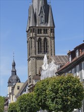 Historic church next to half-timbered houses with green trees and blue sky, Detmold, North