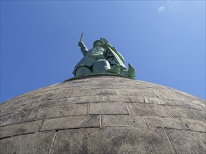 Large statue photographed from below, silhouetted against a clear sky, detmold, North