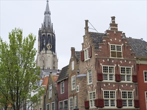 Historic city view with a high church tower in the background and old buildings in the foreground,