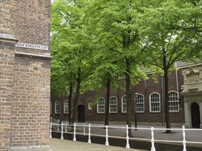 Historic Oude Kerkstraat neighbourhood with old buildings, trees and a canal, Delft, Netherlands