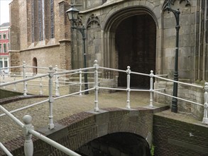 Small bridge in front of a church with decorative railings and old lanterns, Delft, Holland,