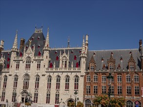 Magnificent historic buildings in Gothic style, decorated with red accents and roofs under a bright