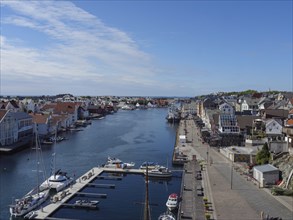 Long harbour with boats on a promenade in sunny weather and clear skies, haugesund, norway,