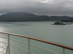 View from a ship on a calm water landscape with cloudy sky and Bergen, Eidfjörd, Norway,