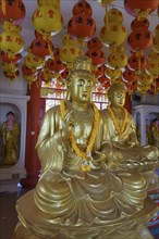 Golden Buddhist statues and decorative lanterns inside a temple, Pattaya, Thailand, Asia