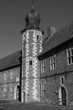 Black and white photograph of a brick tower of a castle, clear structures and strong light,