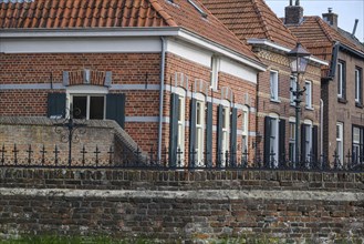 Brick houses with shutters and brick roof, surrounded by a fence, Bredevoort, Gelderlande,