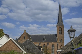 Close-up of a church tower and a street lamp in a village under a cloudy sky, Bredevoort,