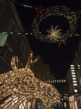 Christmas decorated night street with illuminated wreath and moss figure, bocholt, Münsterland,