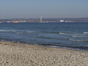 View from the beach to the sea with small waves and distant buildings, Binz, Rügen, Germany, Europe