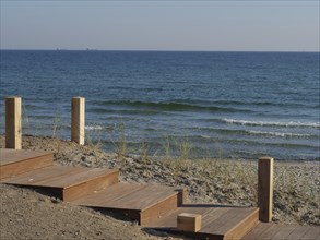 Wooden staircase leads to the sandy beach with a view of the calm sea, Binz, Rügen, Germany, Europe