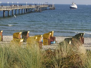 Pier with boat and beach chairs on a sunny beach, Binz, Rügen, Germany, Europe