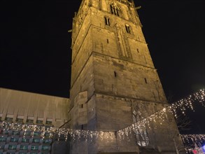 Night shot of a large church with Christmas lighting and fairy lights, Ahaus, Münsterland, North