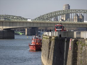 Fire boat on the river near a bridge with urban view and architectural landmarks in the background,