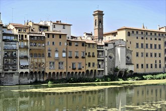 Florence, Tuscany, Italy, Europe, Historic buildings along a river are reflected in the calm water,