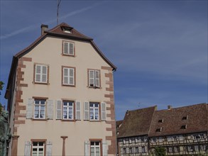 Historic building in an old town centre with white and blue shutters and half-timbered details