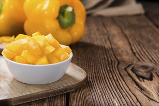 Portion of yellow Peppers (sliced, selective focus) on wooden background