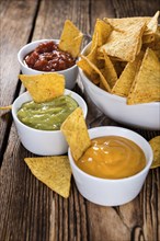 Three different nacho dips (Salsa, Cheese and Guacamole)