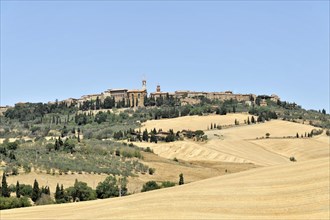 Harvested wheat fields, landscape south of Pienza, Tuscany, Italy, Europe, View of a historic town