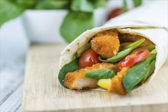 Chicken Wraps on a wooden table as detailed close-up shot (selective focus)