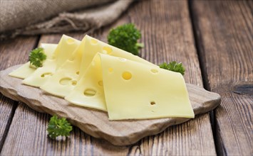 Sliced Cheese (close-up shot) on vintage wooden background