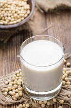 Soy Milk with some Seeds (close-up shot) on wooden background