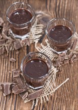 Glass with Chocolate Liqueur (close-up shot) on rustic background