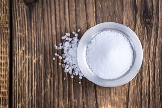 Portion of crushed Salt (close-up shot) on rustic wooden background