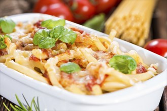 Fresh made Pasta Bake on an old wooden table (close-up shot)