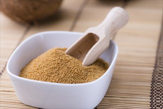 Portion of Coco Sugar (selective focus) on a vintage wooden table