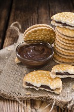 Portion of Chocolate Cream Cookies (on wooden background)