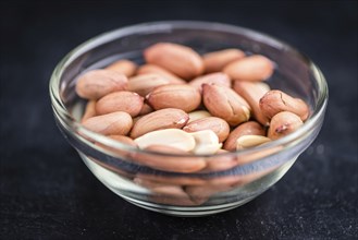 Portion of Peanut Seeds on rustic background (selective focus, close-up shot)