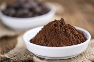 Cocoa powder (selective focus) as detailed close-up shot on wooden background