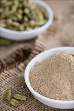 Cardamon Powder on wooden background (detailed close-up shot)