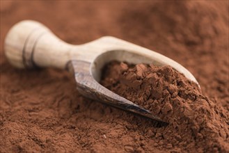 Cocoa powder (selective focus) as detailed close-up shot on wooden background